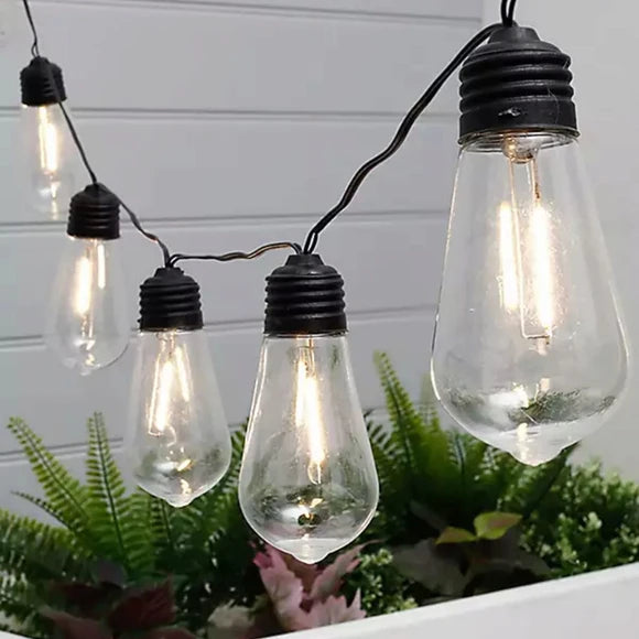 Solar LED string lights illuminating an outdoor patio or garden setting at night
